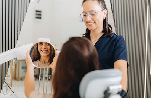 Woman smiling while looking at reflection in mirror