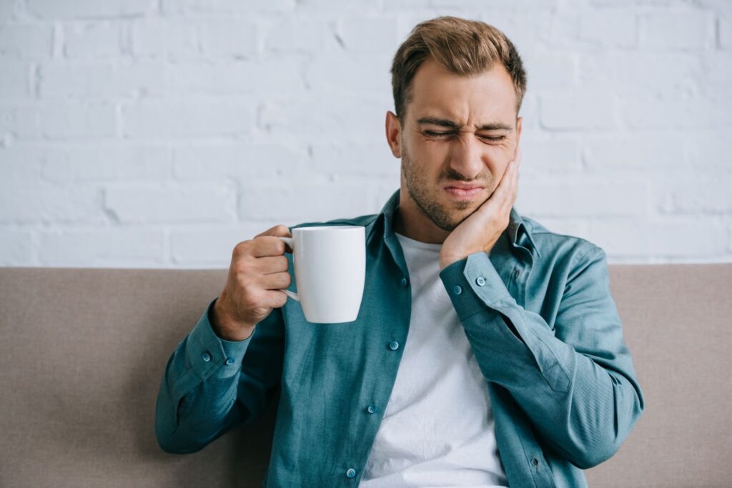 A man clutching his jaw from a toothache.